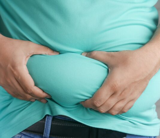 “다이어트는 했는데 배는 그대로”… 뱃살이 안 빠지는 진짜 이유 a man holding his stomach with his hands
