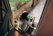 만성피로, 일상을 바꾸는 작지만 강력한 루틴의 힘 Woman sitting on balcony with smartphone