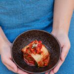 “항염 식단으로 염증과 이별하기: 여러분의 건강을 지키는 간단한 방법” black ceramic bowl on blue textile
