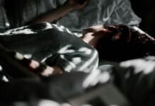 “숙면이 대세! 일상 속에서 쉽게 실천하는 건강한 수면 습관” a person laying in a bed under a blanket